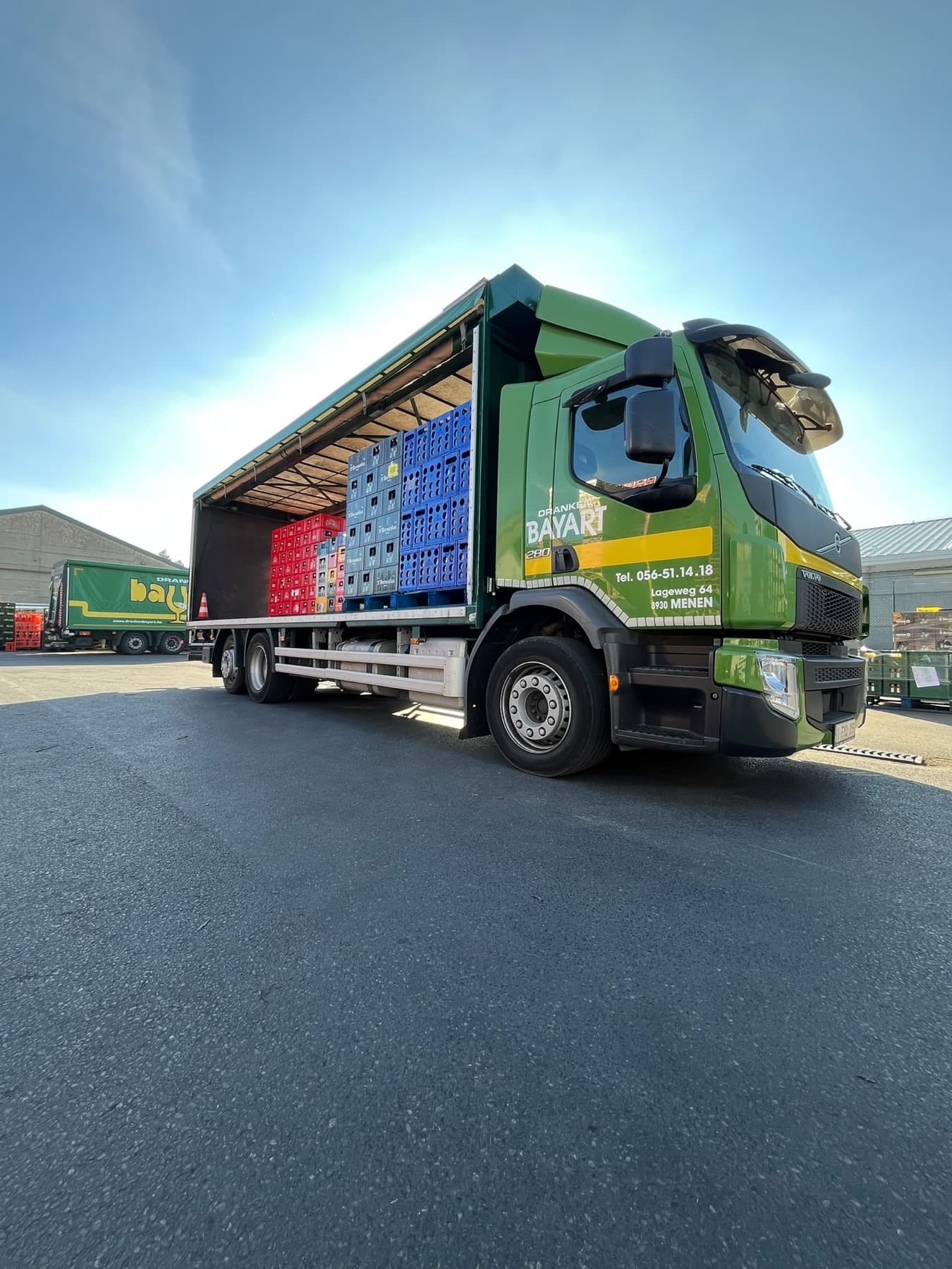 Geladen vrachtwagen van Dranken Bayart met bakken frisdrank en water